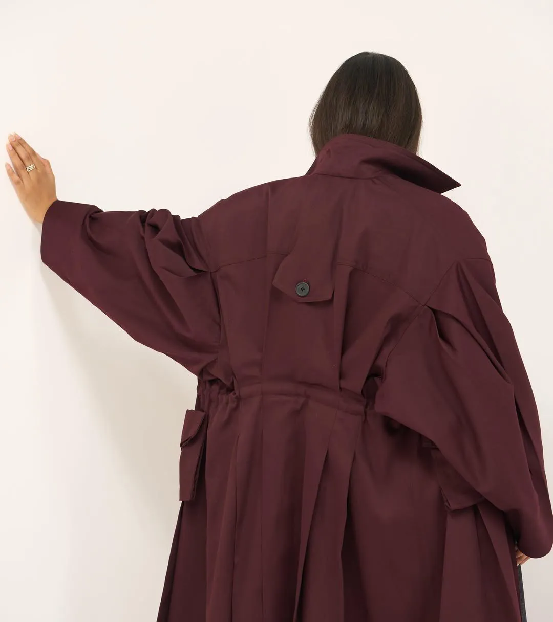 Back of the cherry trench coat with button flap, drawstring waist and pleats