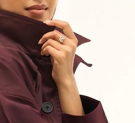 Stacked silver rings: hand with stacked silver rings holding the trench collar
