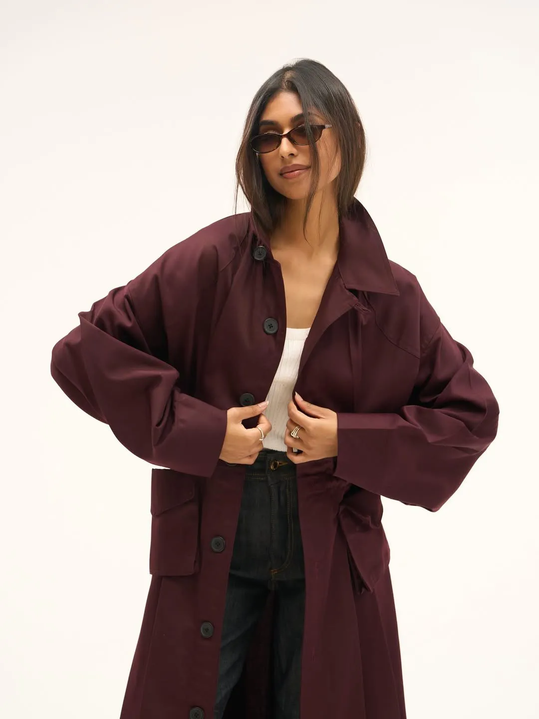 Cherry trench coat worn open over a white ribbed top and dark denim